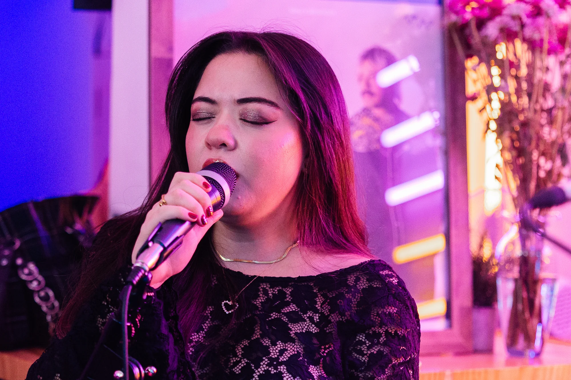 Cassandra singing into a microphone, photographed by Ludovic Delot