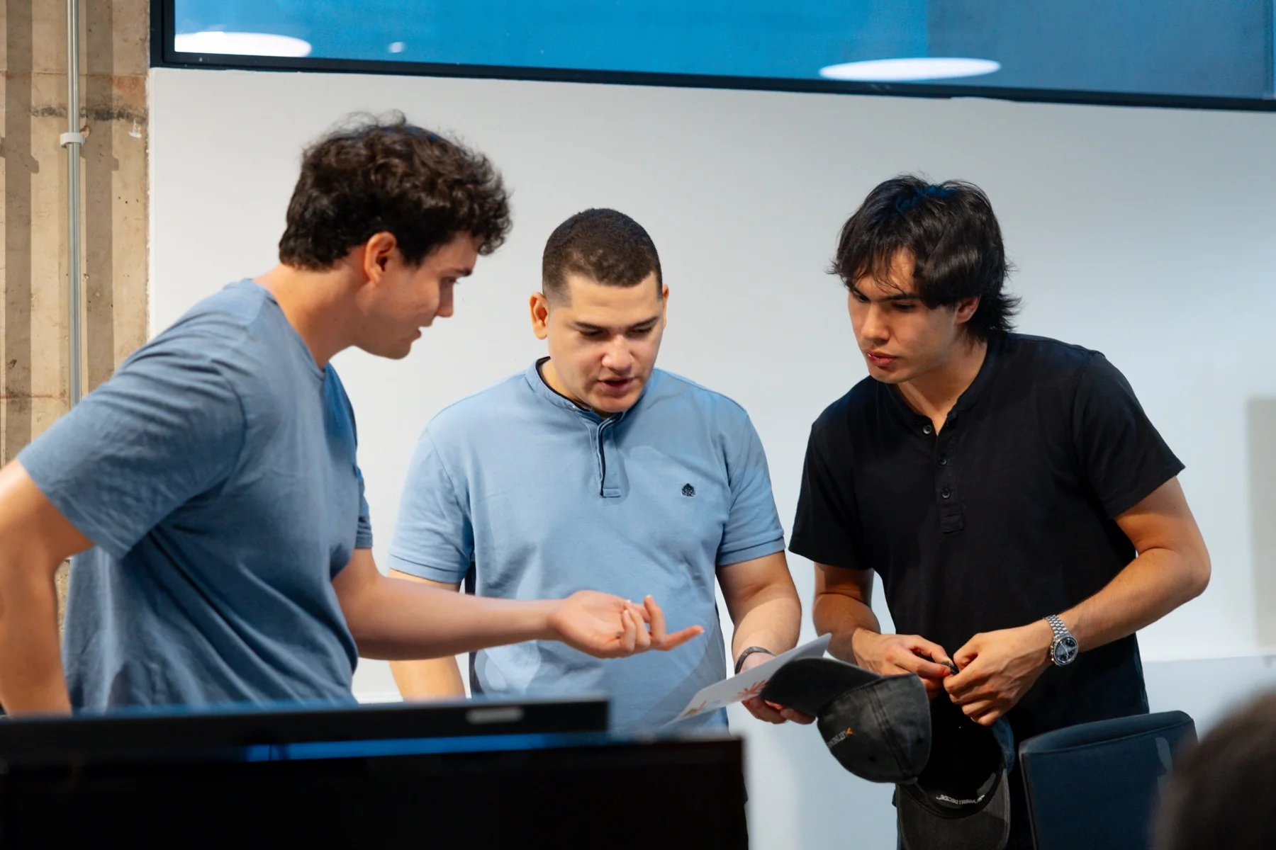 A small team works through a problem together at the Claude Community Madrid Hackathon, photographed by Ludovic Delot