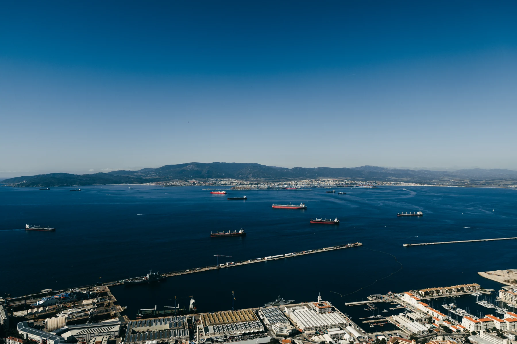 Gibraltar's harbour, breakwaters and anchored ships seen from the Upper Rock on a clear day.